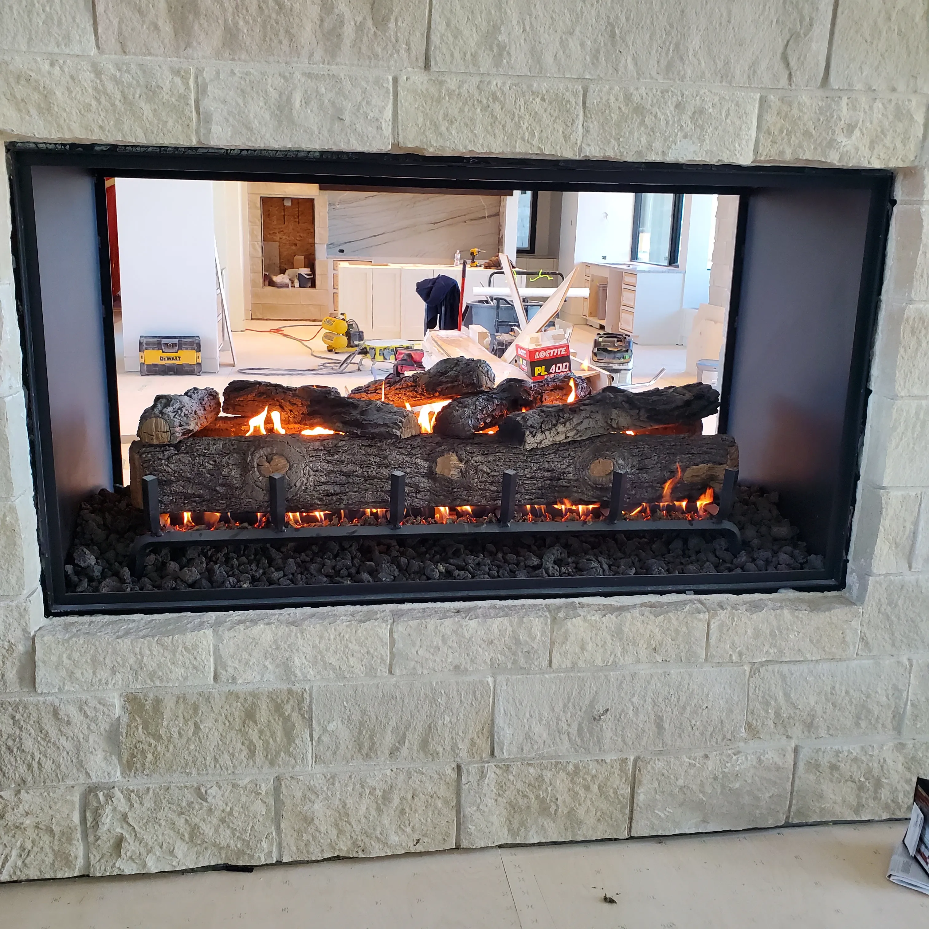 Custom stone fireplace with live fire and log set
