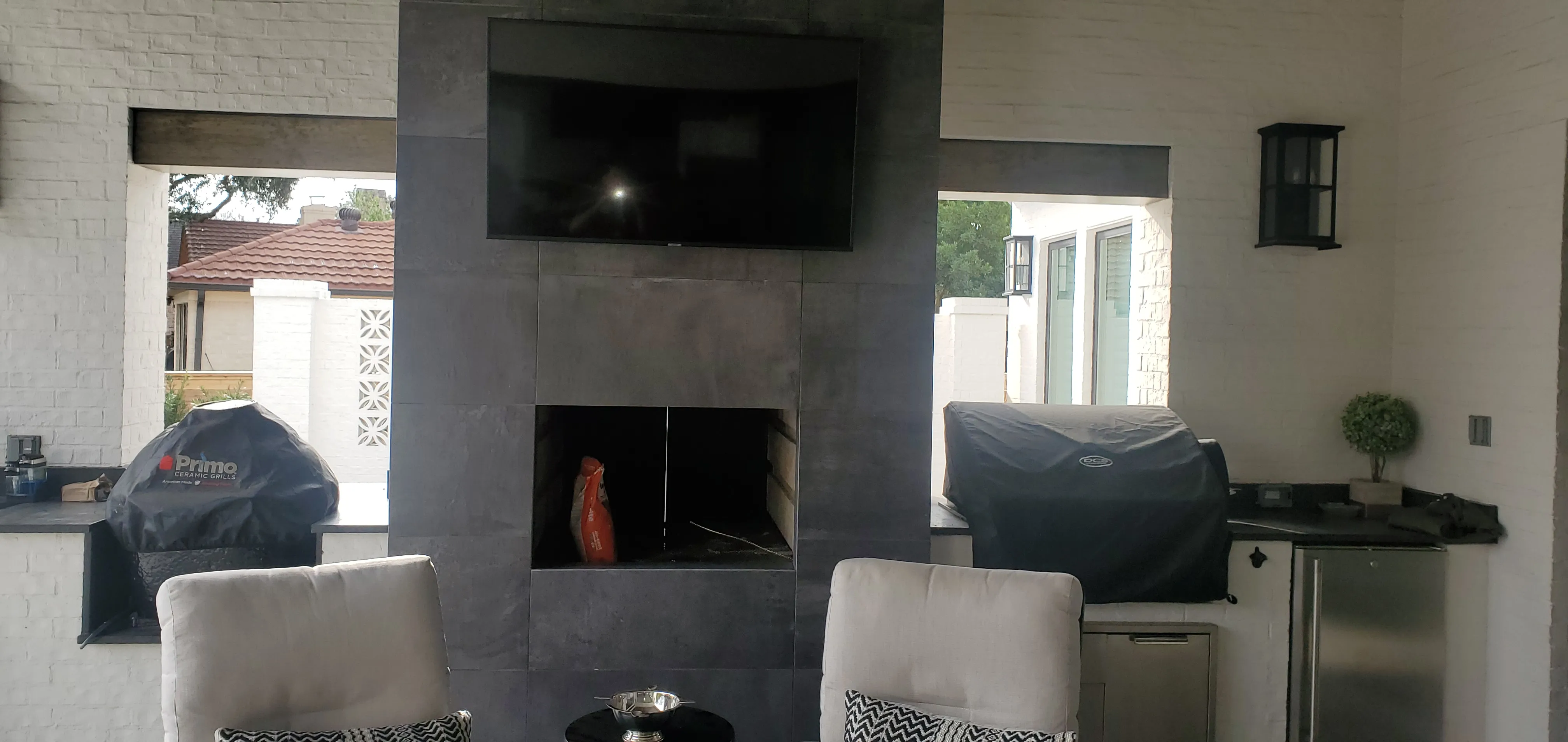 Premium outdoor patio fireplace with dark tile surround, installed by Chim-Tex Construction